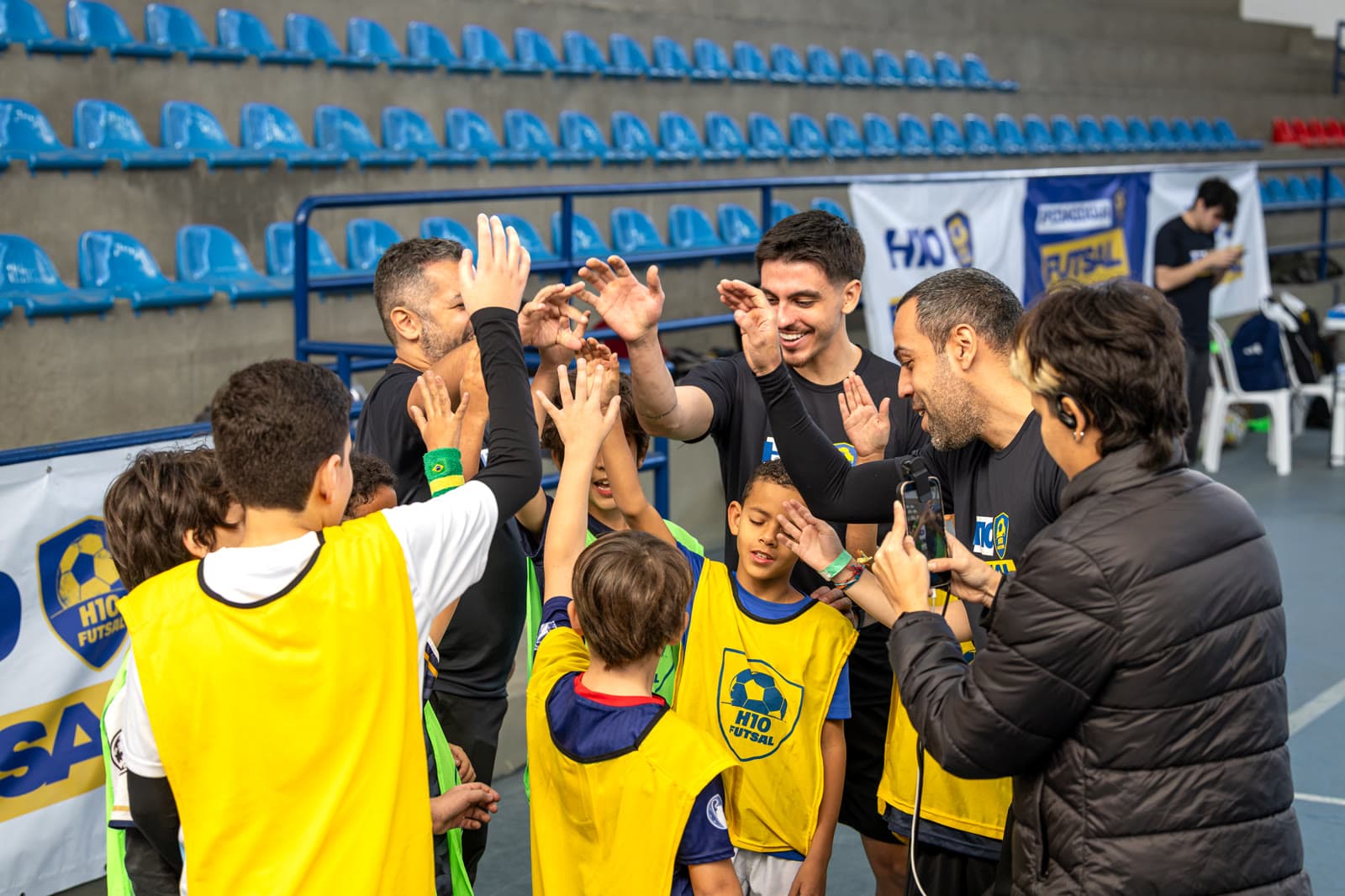 Staff e crianças com as mãos erguidas em comemoração