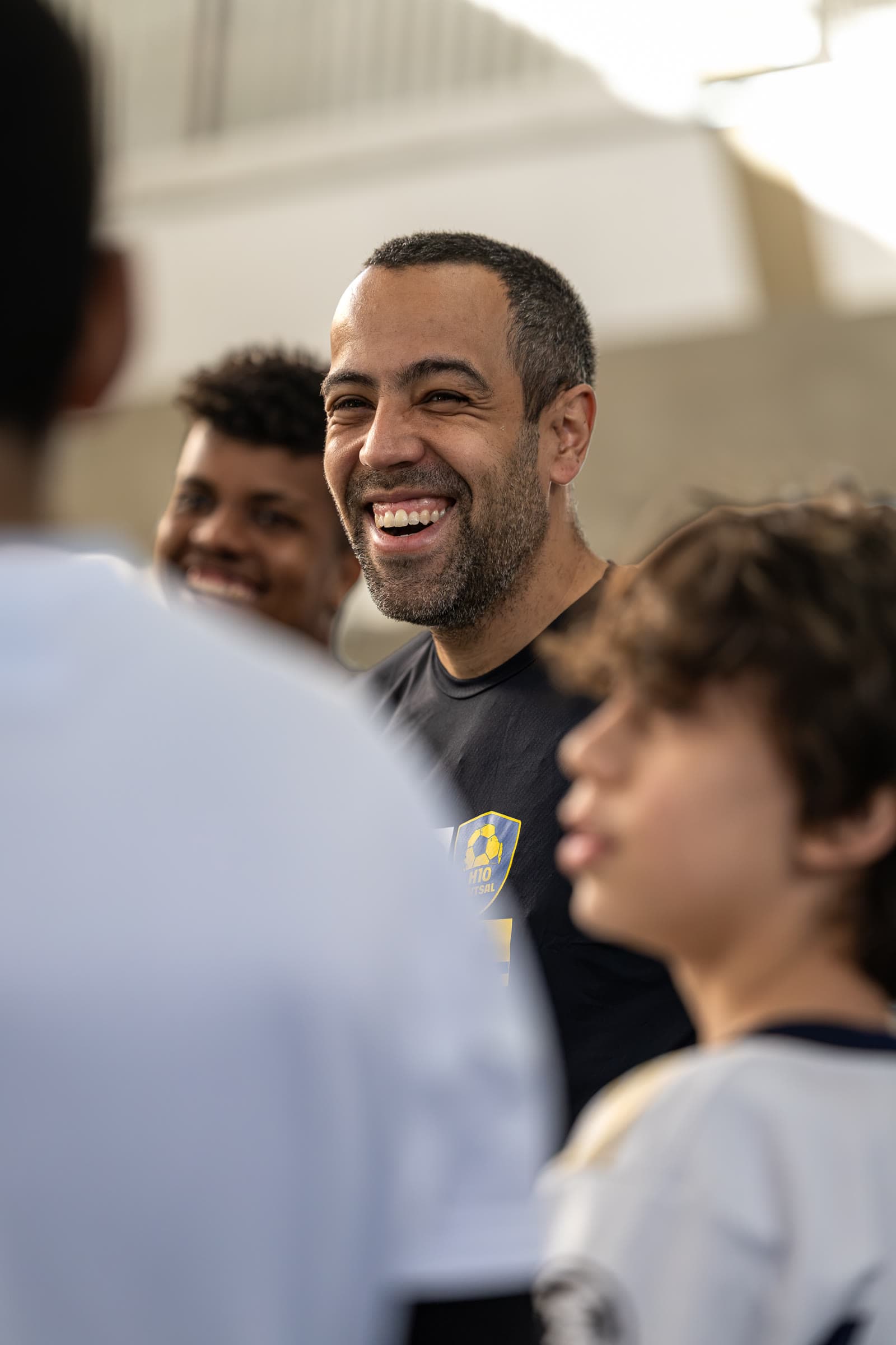 Treinador sorrindo em momento candido na arquibancada