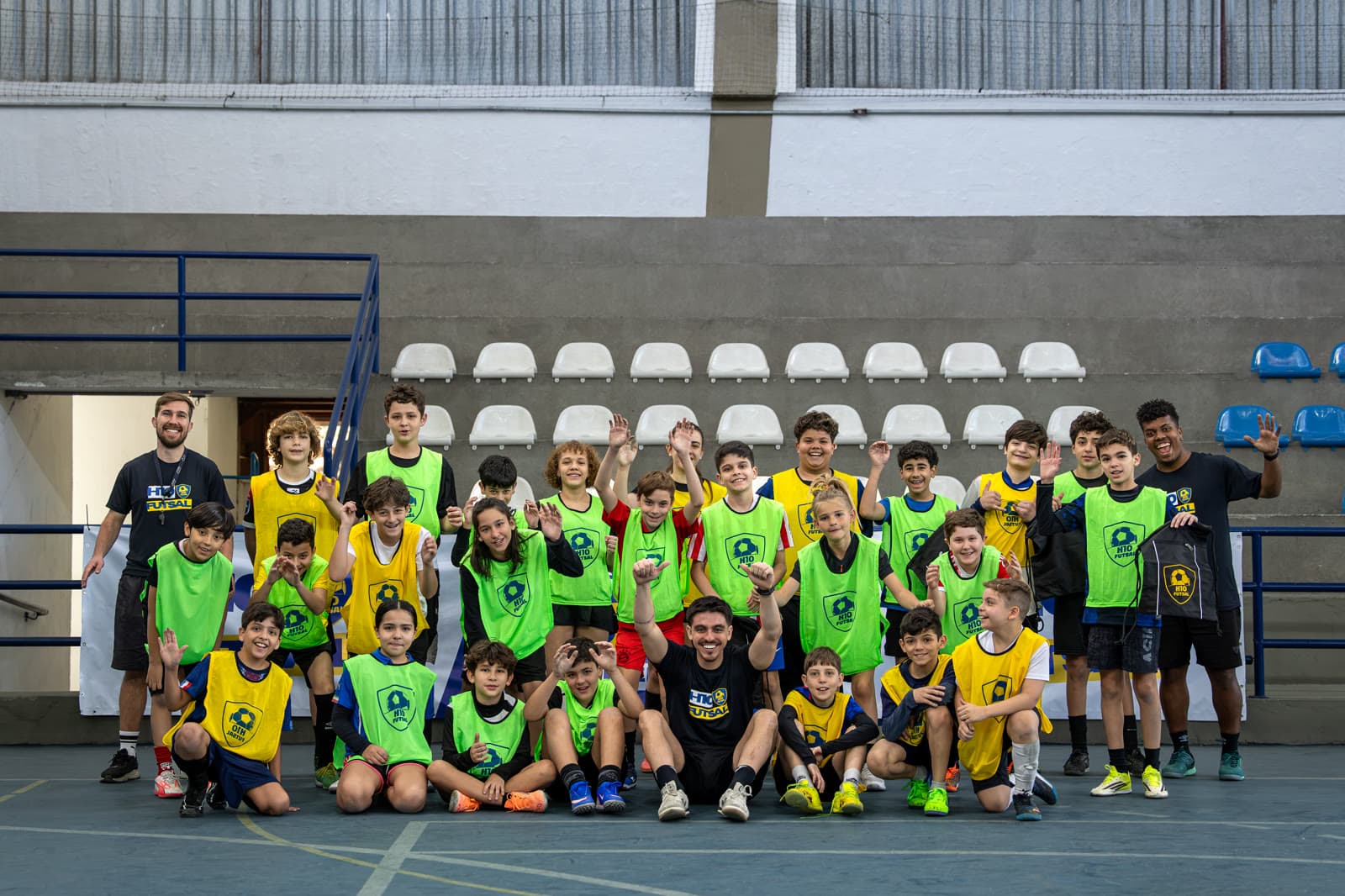 Turma completa comemorando em quadra, sorrindo para a foto