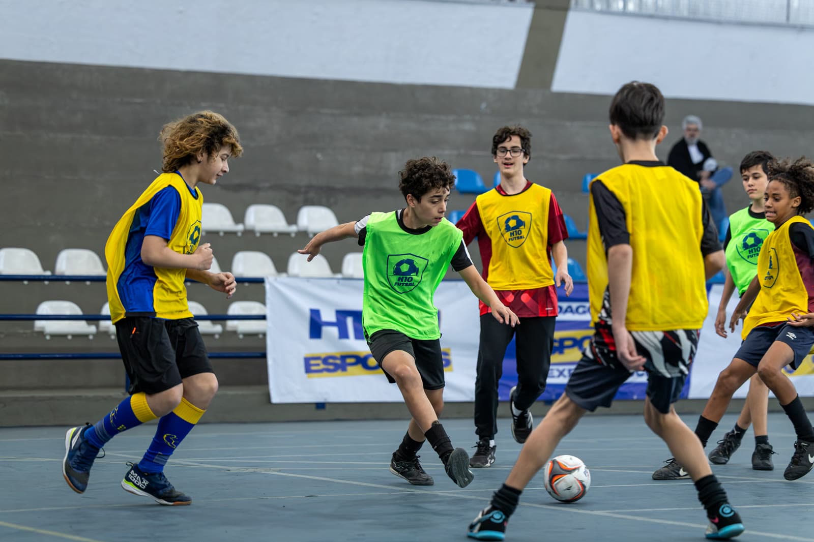 Adolescentes disputando a bola em quadra