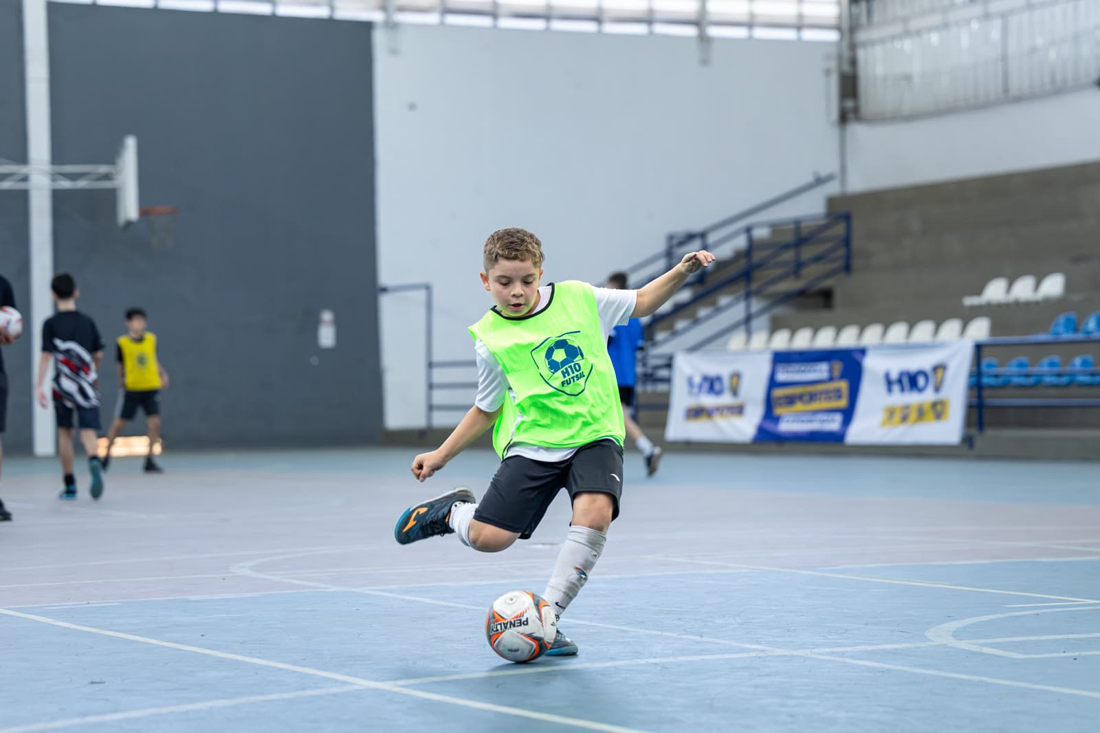 Atleta finalizando em quadra poliesportiva, área externa da Estância